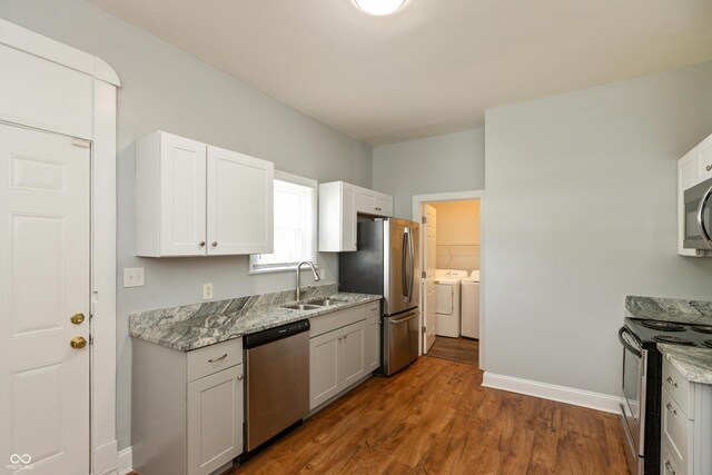 1661 S Talbott St, Indianapolis, IN 46225 - kitchen featuring appliances with stainless steel finishes, a sink, independent washer and dryer, dark wood-type flooring, and baseboards