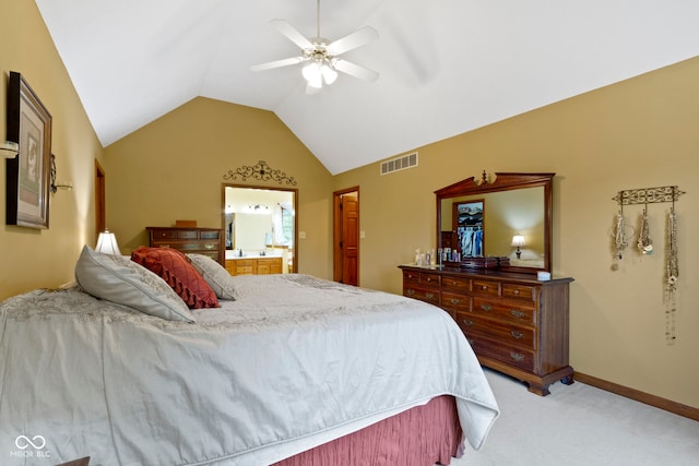 bedroom featuring light carpet, lofted ceiling, ceiling fan, ensuite bath, and baseboards