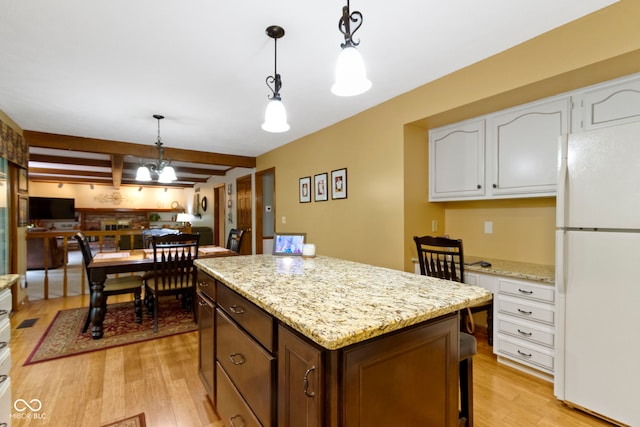 kitchen featuring freestanding refrigerator, light wood-style flooring, white cabinets, beam ceiling, and a center island