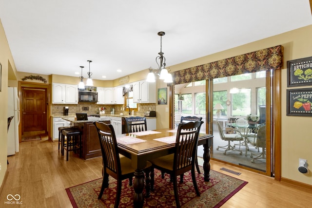 dining area featuring light wood finished floors and recessed lighting