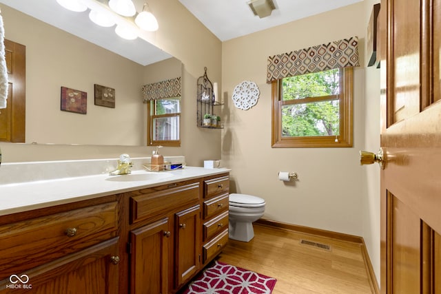 bathroom with wood finished floors, baseboards, toilet, and vanity