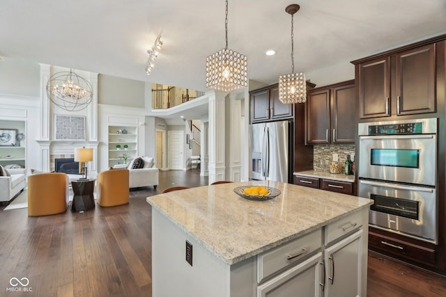 3744 Abney Point Dr, Carmel, IN 46077 - kitchen with stainless steel appliances, a chandelier, open floor plan, light stone counters, and decorative backsplash