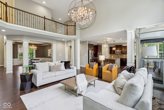3744 Abney Point Dr, Carmel, IN 46077 - living room with ornate columns, a chandelier, recessed lighting, dark wood-type flooring, and a towering ceiling