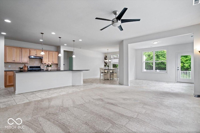 16573 Cava Dr, Fishers, IN 46037 - kitchen with recessed lighting, dark countertops, under cabinet range hood, open floor plan, and light colored carpet
