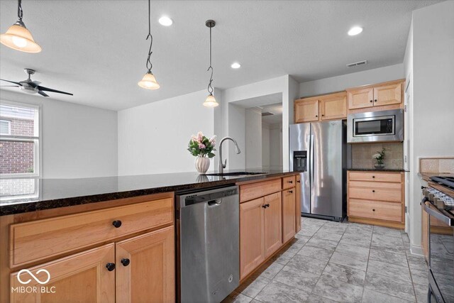 16573 Cava Dr, Fishers, IN 46037 - kitchen with appliances with stainless steel finishes, a sink, light brown cabinetry, a ceiling fan, and hanging light fixtures