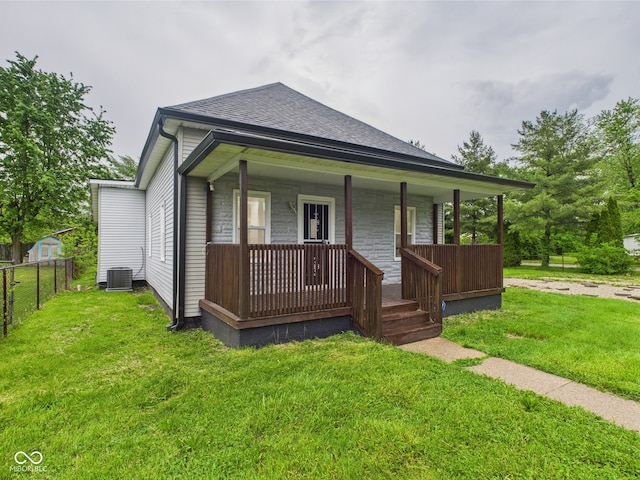 view of front of house with a porch, a shingled roof, and central AC