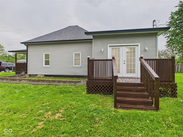 rear view of property with french doors, a wooden deck, a yard, and a shingled roof