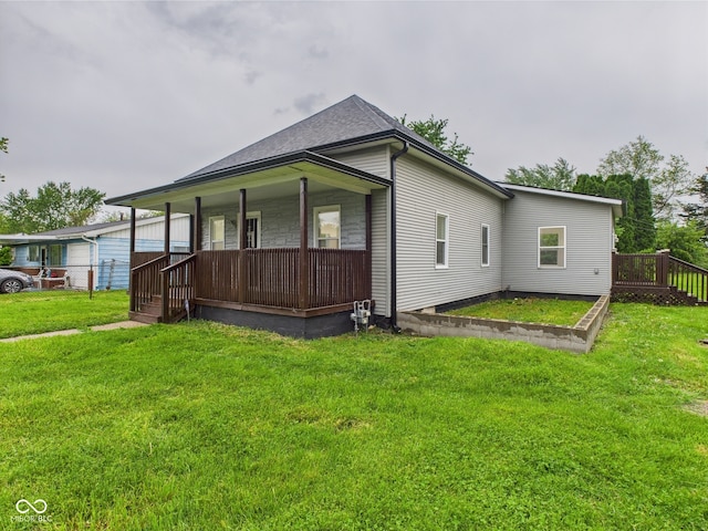 view of side of home with a porch and a lawn
