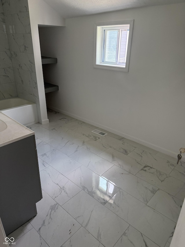 1322 S Belmont Ave, Indianapolis, IN 46221 - full bathroom featuring marble look tile flooring, baseboards, vanity, and a bath
