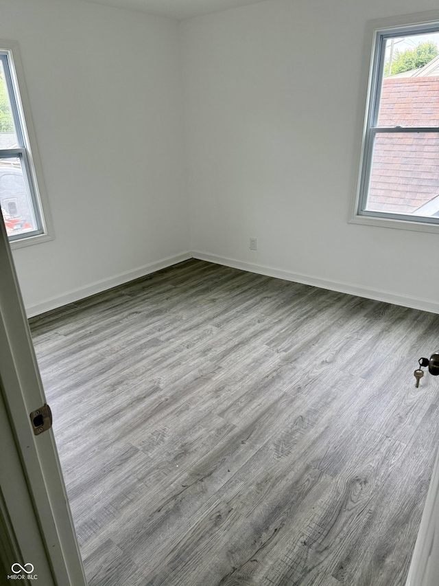 1322 S Belmont Ave, Indianapolis, IN 46221 - unfurnished room featuring wood finished floors, healthy amount of natural light, and baseboards