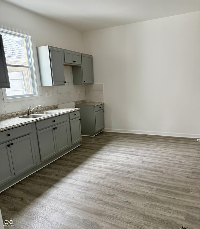 1322 S Belmont Ave, Indianapolis, IN 46221 - kitchen with a sink, backsplash, light wood finished floors, and gray cabinetry