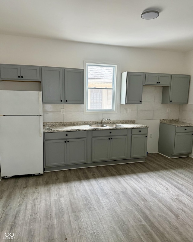 1322 S Belmont Ave, Indianapolis, IN 46221 - kitchen featuring freestanding refrigerator, a sink, light wood-style floors, and gray cabinetry