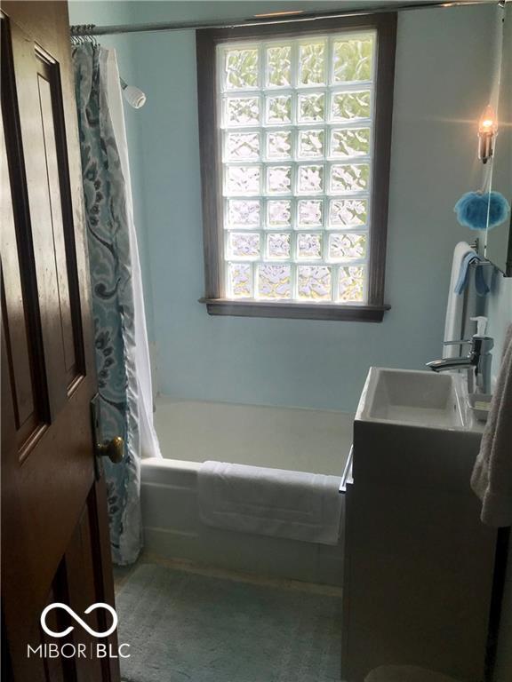 1714 Jefferson St, Anderson, IN 46016 - full bath featuring plenty of natural light, vanity, and shower / bath combination with curtain