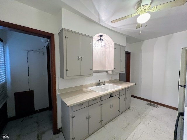 1714 Jefferson St, Anderson, IN 46016 - kitchen with a sink, gray cabinetry, light countertops, ceiling fan, and light marble finish flooring