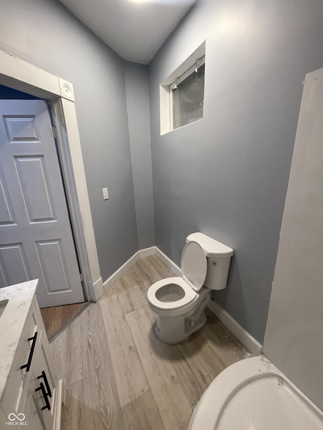 2116 Prospect St, Indianapolis, IN 46203 - bathroom featuring toilet, wood finished floors, vanity, and baseboards