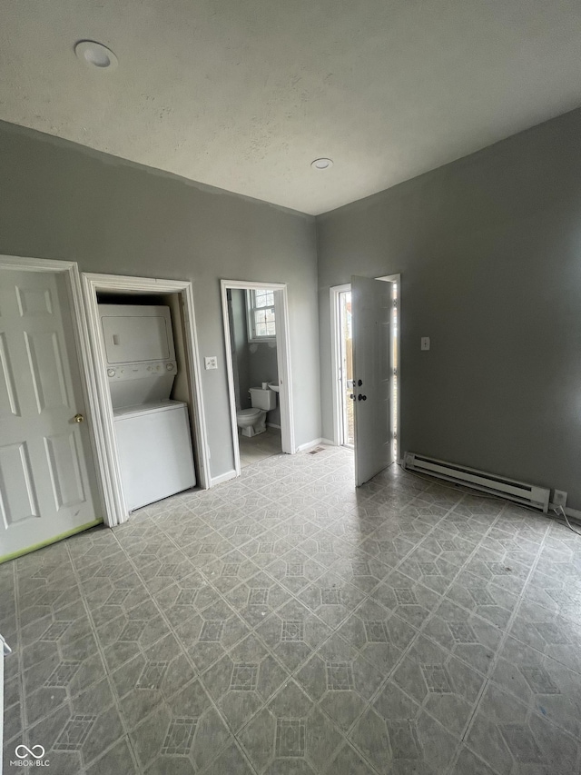 2116 Prospect St, Indianapolis, IN 46203 - empty room featuring stacked washer / drying machine and a baseboard heating unit