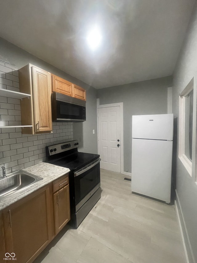 2116 Prospect St, Indianapolis, IN 46203 - kitchen featuring stainless steel appliances, a sink, open shelves, backsplash, and baseboards