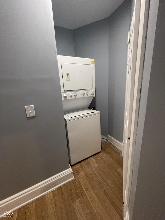 2116 Prospect St, Indianapolis, IN 46203 - laundry area featuring stacked washer and clothes dryer, wood finished floors, and baseboards
