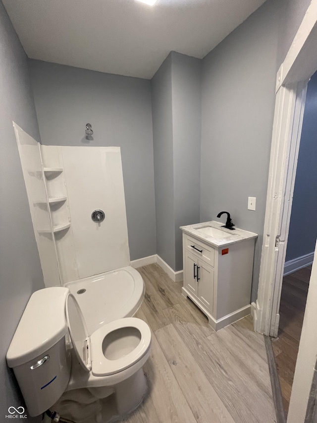 2116 Prospect St, Indianapolis, IN 46203 - bathroom featuring toilet, wood finished floors, vanity, and baseboards