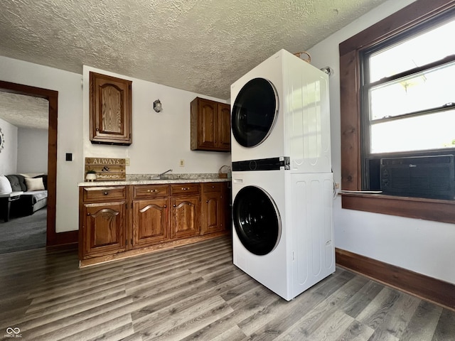 600 S Oak St, Fortville, IN 46040 - laundry room featuring stacked washer and clothes dryer, light wood-style floors, baseboards, a textured ceiling, and cooling unit