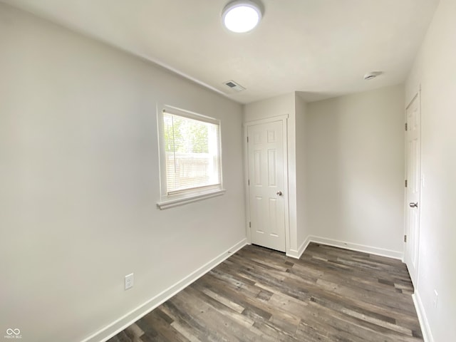6150 E 25th St, Indianapolis, IN 46219 - unfurnished bedroom with baseboards and dark wood finished floors