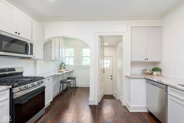 1502 Burdsal Pkwy, Indianapolis, IN 46208 - kitchen with appliances with stainless steel finishes, tasteful backsplash, dark wood-style floors, light stone countertops, and white cabinets