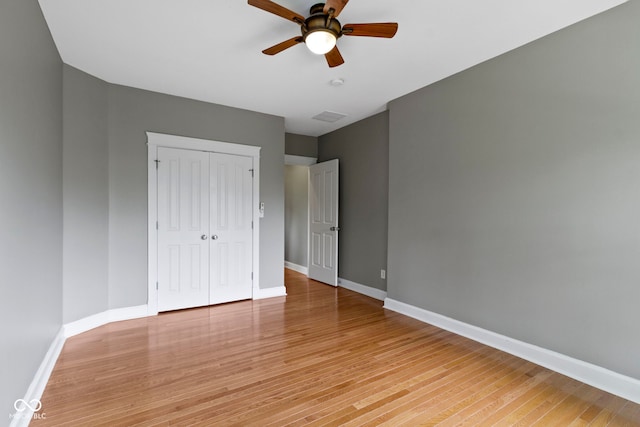 1526 Carrollton Ave, Indianapolis, IN 46202 - unfurnished bedroom featuring baseboards, a closet, light wood-style flooring, and ceiling fan