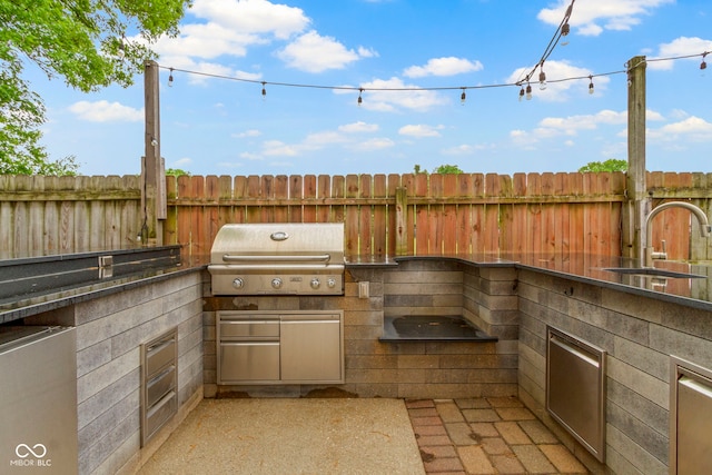 1526 Carrollton Ave, Indianapolis, IN 46202 - view of patio with a grill, a sink, fence, and an outdoor kitchen