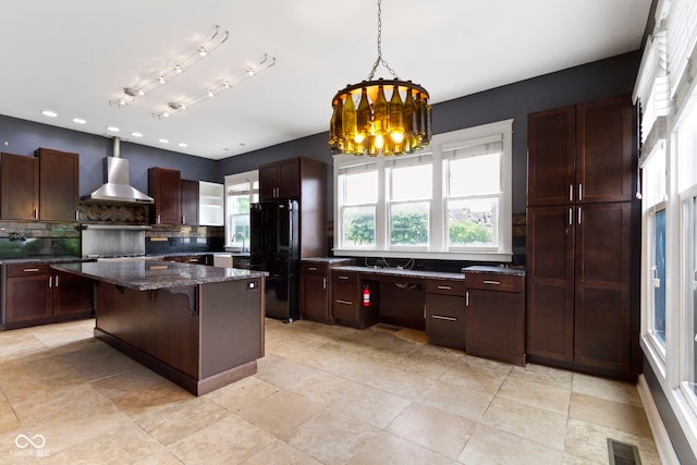 1526 Carrollton Ave, Indianapolis, IN 46202 - kitchen with freestanding refrigerator, wall chimney range hood, backsplash, pendant lighting, and a breakfast bar