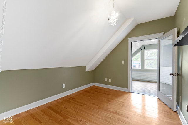 1526 Carrollton Ave, Indianapolis, IN 46202 - additional living space with lofted ceiling, light wood-type flooring, a chandelier, and baseboards