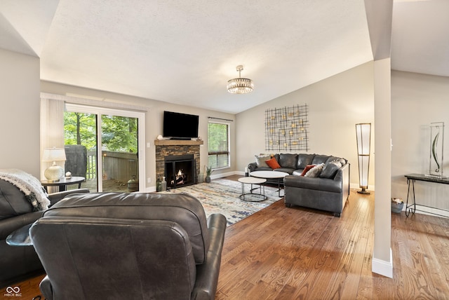 35 Osage Ct, Columbus, IN 47201 - living area with wood finished floors, vaulted ceiling, baseboards, and a stone fireplace