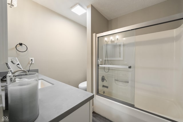35 Osage Ct, Columbus, IN 47201 - full bathroom featuring double vanity, combined bath / shower with glass door, toilet, and a textured ceiling