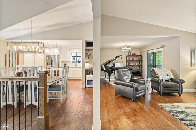 35 Osage Ct, Columbus, IN 47201 - living area with lofted ceiling, a chandelier, and wood finished floors