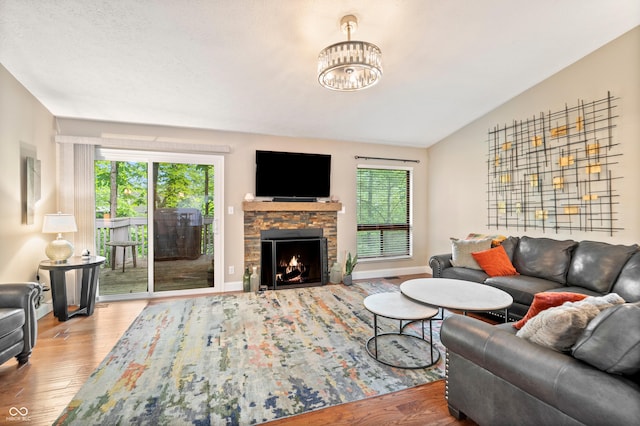 35 Osage Ct, Columbus, IN 47201 - living room featuring wood finished floors, healthy amount of natural light, a stone fireplace, and lofted ceiling