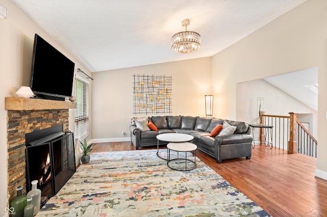 35 Osage Ct, Columbus, IN 47201 - living area with vaulted ceiling, wood finished floors, baseboards, a chandelier, and a warm lit fireplace