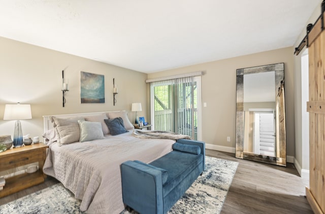 35 Osage Ct, Columbus, IN 47201 - bedroom featuring a barn door, access to outside, wood finished floors, and baseboards