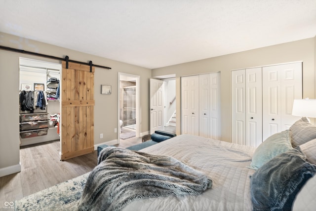 35 Osage Ct, Columbus, IN 47201 - bedroom featuring a barn door, baseboards, wood finished floors, and a spacious closet