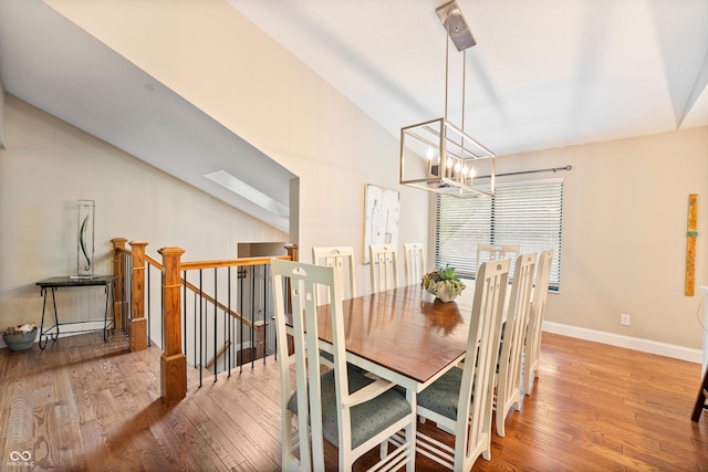 35 Osage Ct, Columbus, IN 47201 - dining room featuring wood finished floors, a chandelier, baseboards, and vaulted ceiling