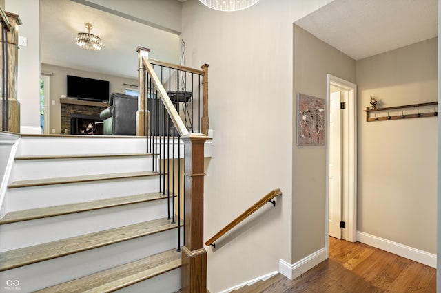 35 Osage Ct, Columbus, IN 47201 - stairway with baseboards, wood finished floors, and a stone fireplace