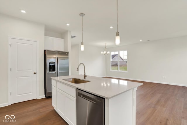 104 Maxim Ct, Cumberland, IN 46229 - kitchen with appliances with stainless steel finishes, a sink, wood finished floors, white cabinetry, and a chandelier