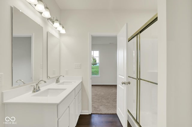 104 Maxim Ct, Cumberland, IN 46229 - bathroom featuring double vanity, wood finished floors, baseboards, and a shower with shower door