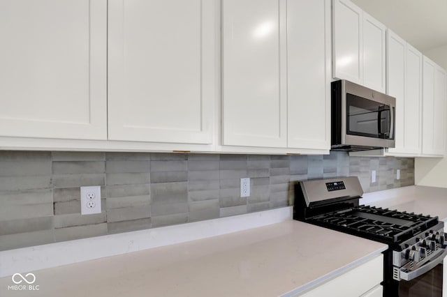 104 Maxim Ct, Cumberland, IN 46229 - kitchen featuring appliances with stainless steel finishes, white cabinets, decorative backsplash, and light stone countertops