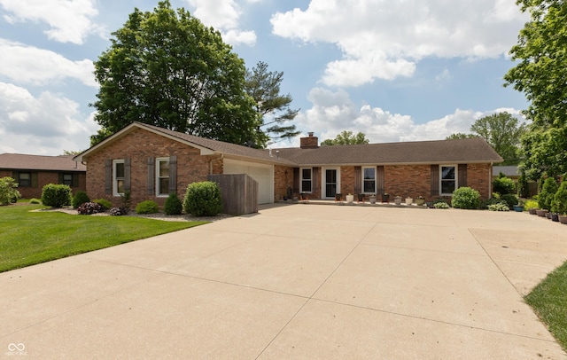 1541 Stadium Dr, Seymour, IN 47274 - ranch-style house with brick siding, concrete driveway, a garage, and a chimney