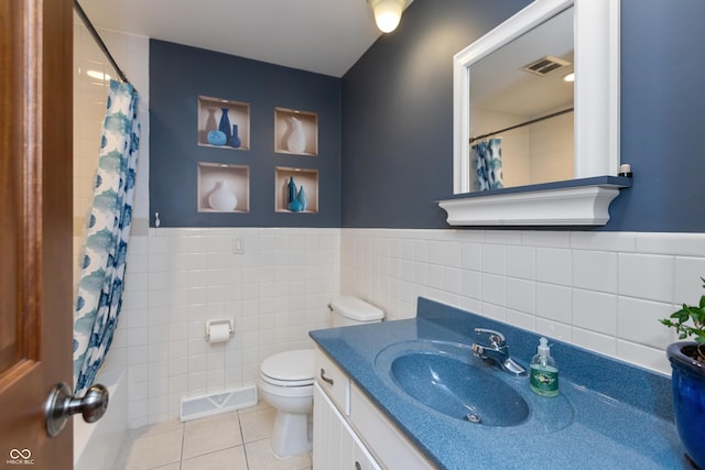 1541 Stadium Dr, Seymour, IN 47274 - full bath with tile walls, tile patterned floors, toilet, vanity, and wainscoting