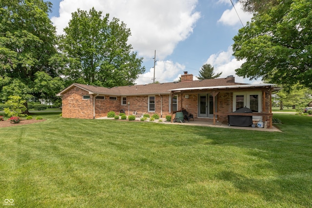 1541 Stadium Dr, Seymour, IN 47274 - back of property with a patio, a chimney, french doors, a lawn, and brick siding