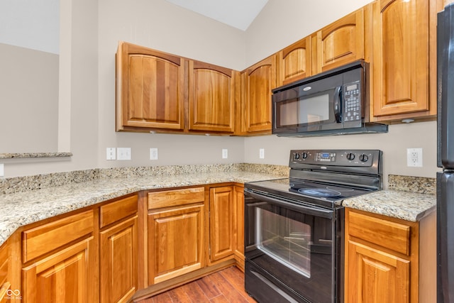 1139 Fernwood Way, Plainfield, IN 46168 - kitchen with black appliances, wood finished floors, light stone counters, and brown cabinetry