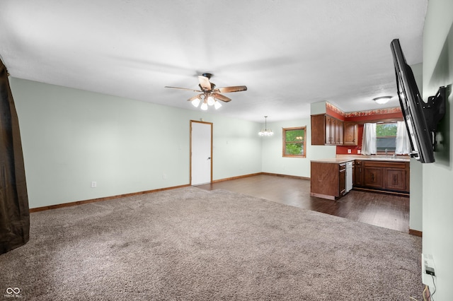 201 Hayden Pike, North Vernon, IN 47265 - unfurnished living room featuring dark colored carpet, a chandelier, ceiling fan, baseboards, and a sink