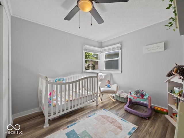547 W Taylor St, Shelbyville, IN 46176 - bedroom with ornamental molding, a nursery area, wood finished floors, a ceiling fan, and a textured ceiling