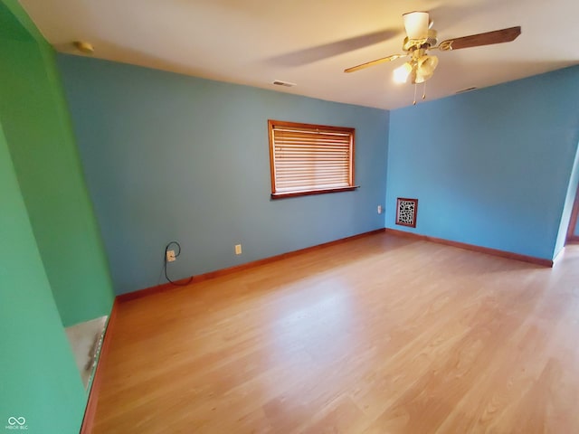 704 E Perry St, Indianapolis, IN 46227 - empty room with wood finished floors, a ceiling fan, and baseboards