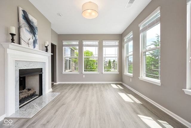 4659 W Otway Ln, New Palestine, IN 46163 - unfurnished living room with wood finished floors, baseboards, plenty of natural light, and a high end fireplace